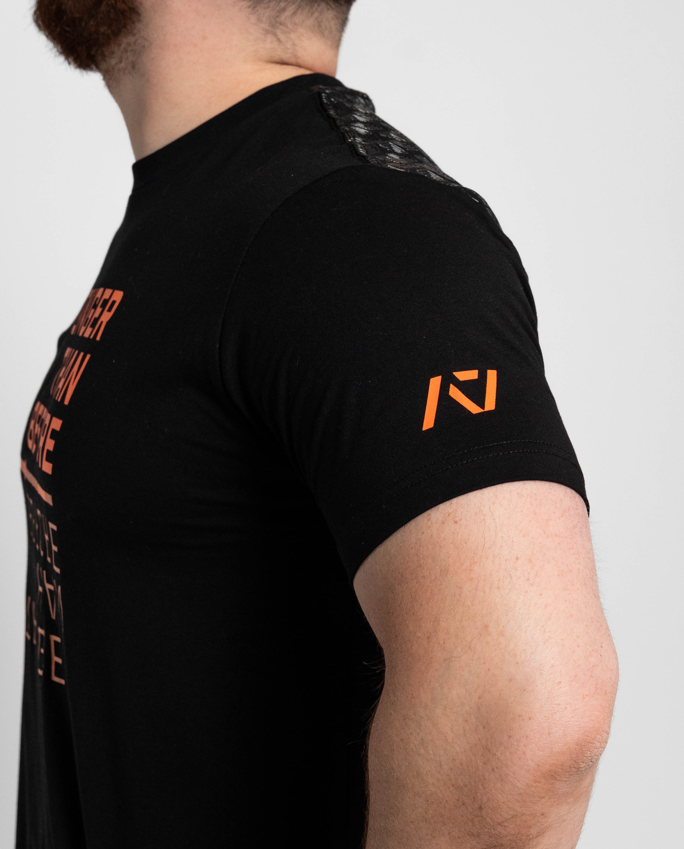 Black t-shirt with orange logo and text on a plain background