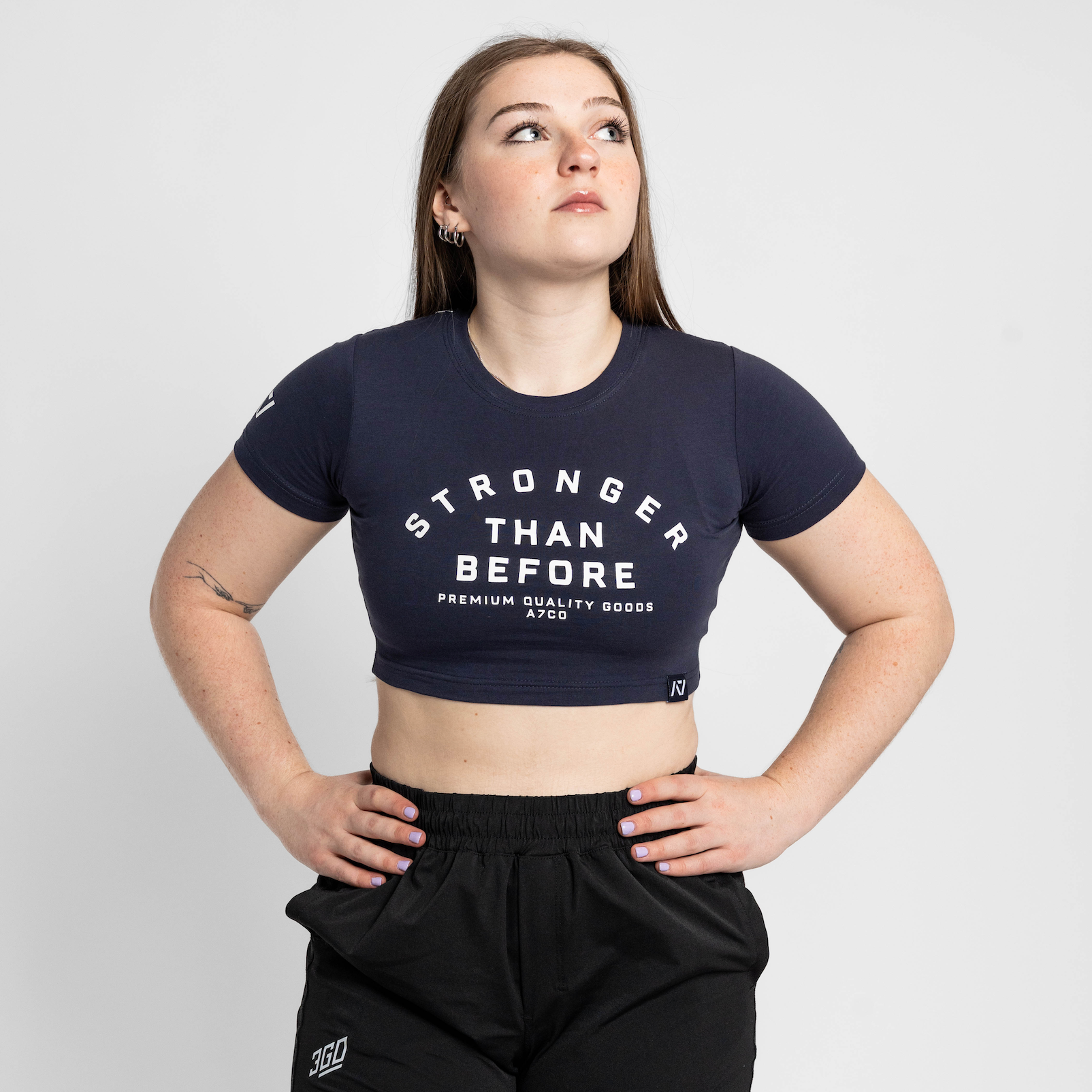 Person wearing a black 'Stronger Than Before' t-shirt and black shorts on a white background