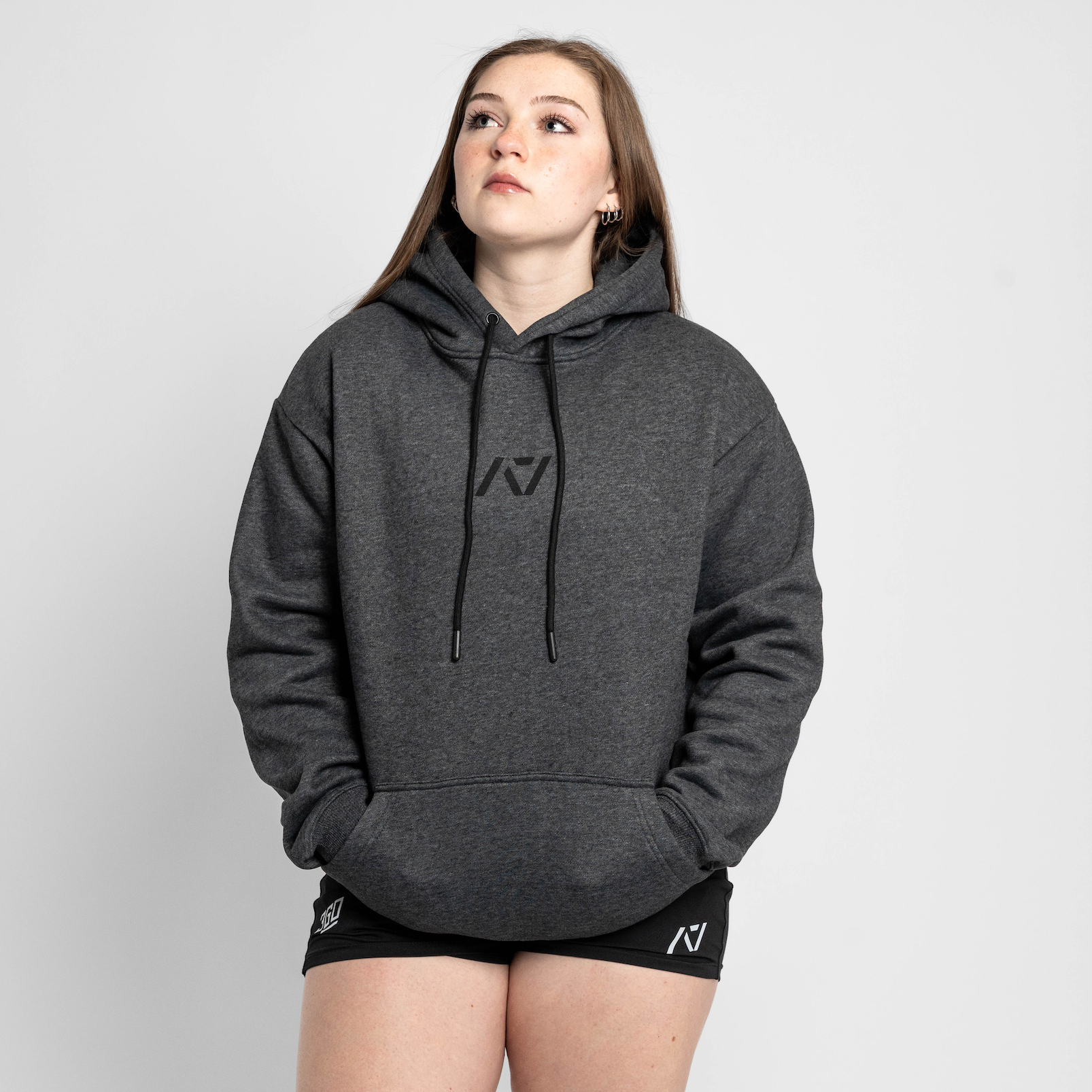Person wearing a gray hoodie with a logo on a white background