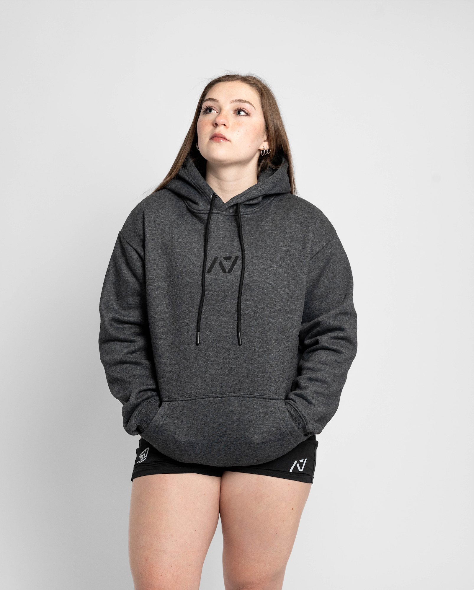 Person wearing a gray hoodie with a logo on a white background
