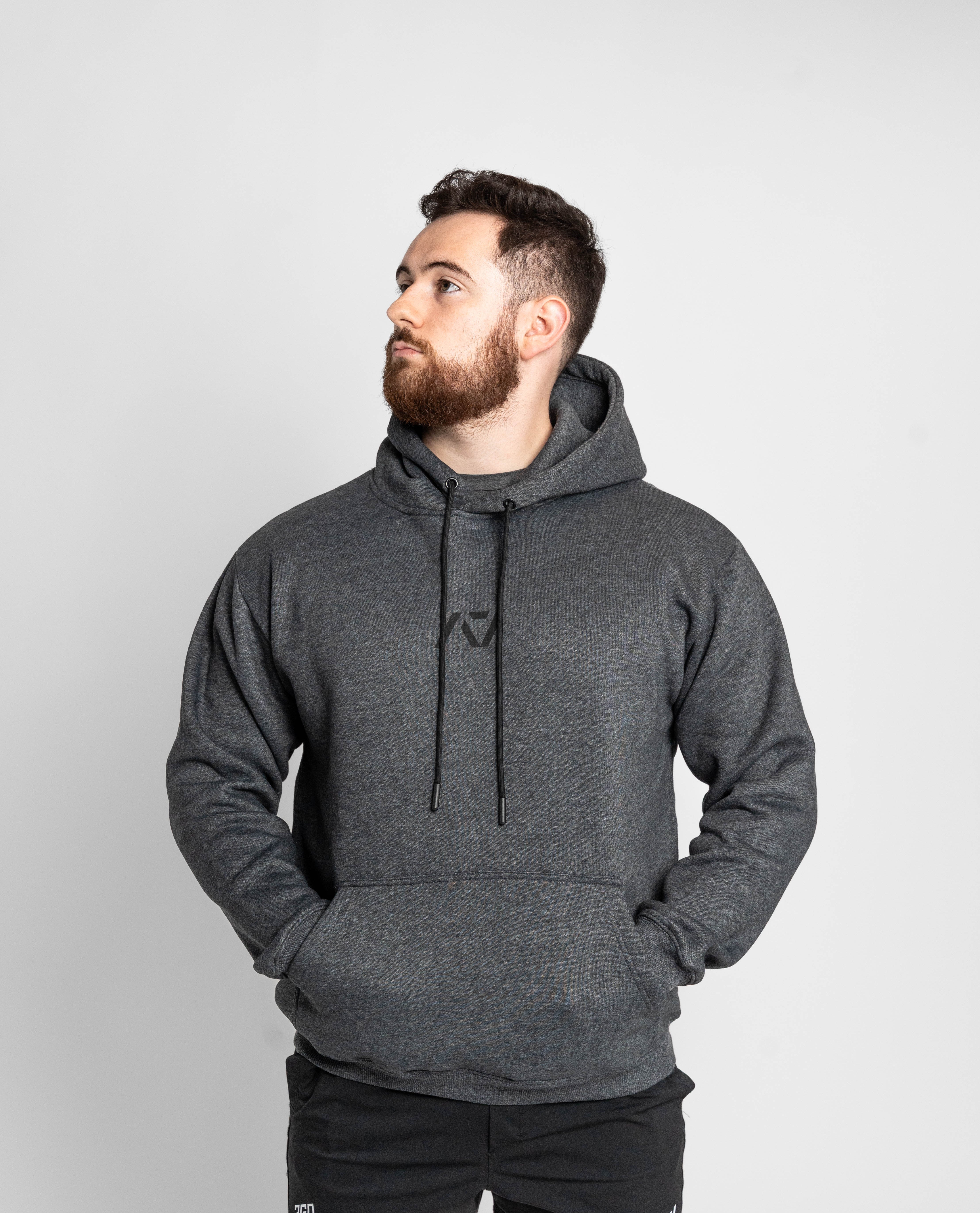 Man wearing a gray hoodie with a logo on a white background