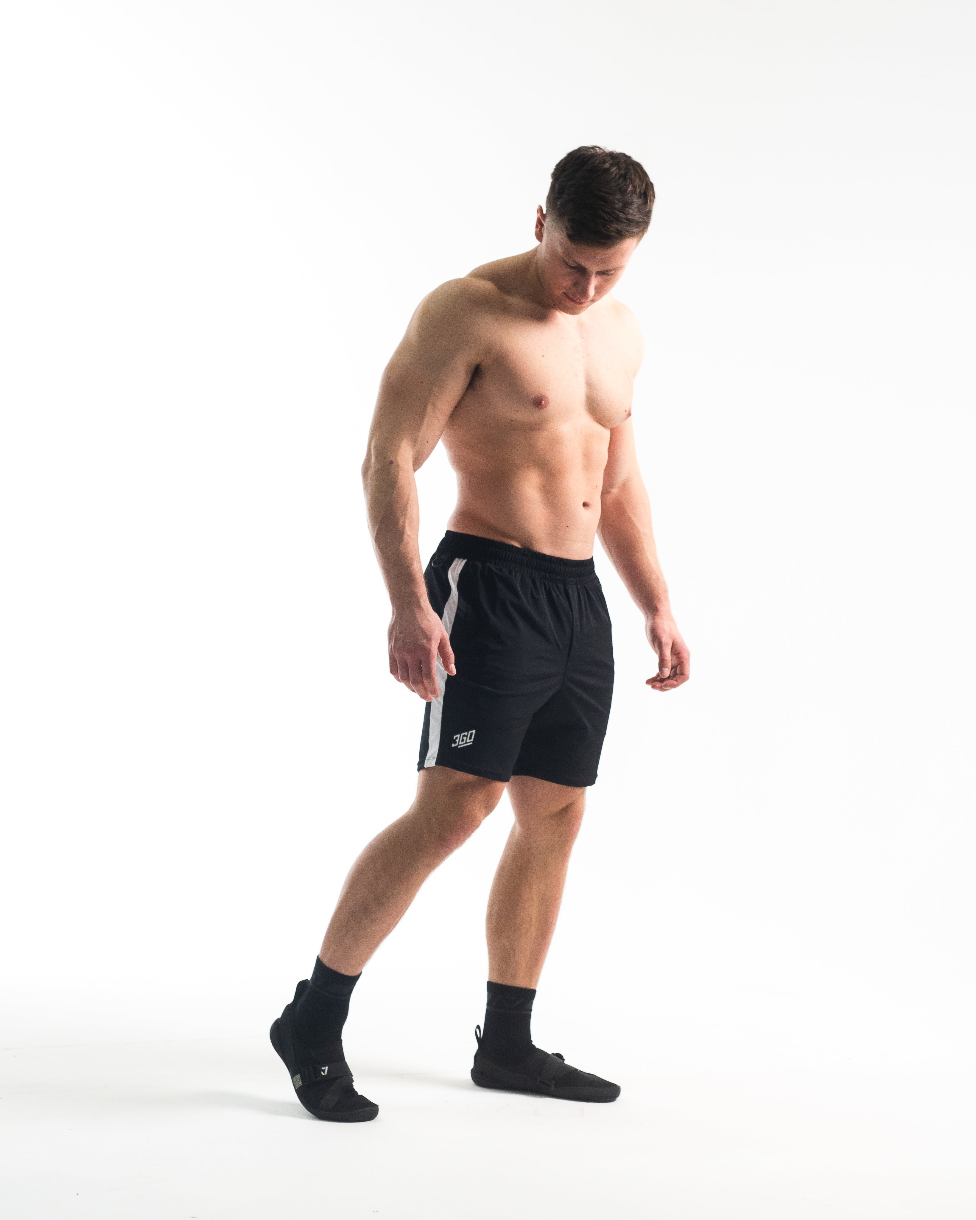 Full body image of athlete wearing A7 360Go KWD Shorts in Domino, showcasing fit, movement, and bold contrast design.