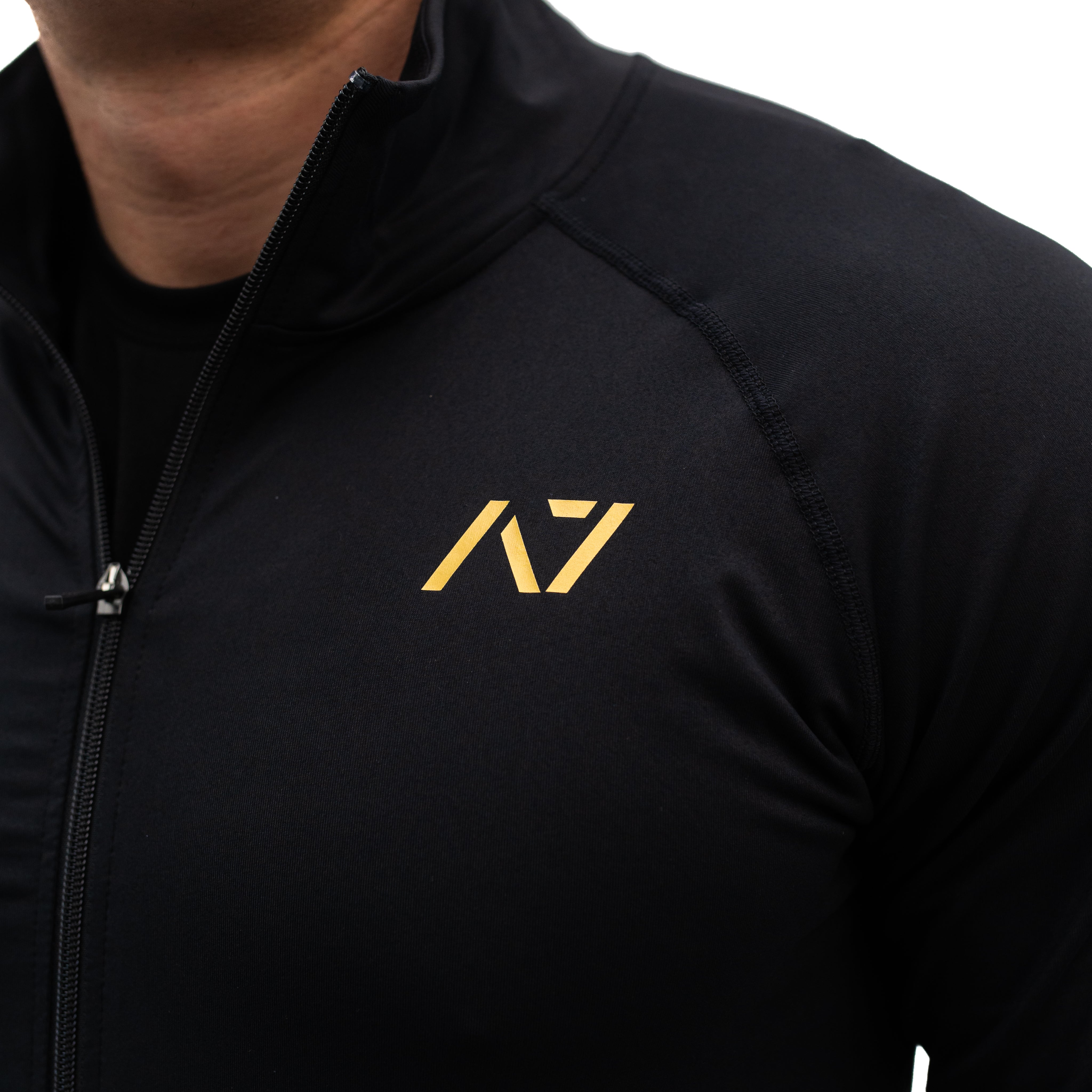 Close-up of the printed gold silicone A7 logo on the chest of the Defy Jacket.