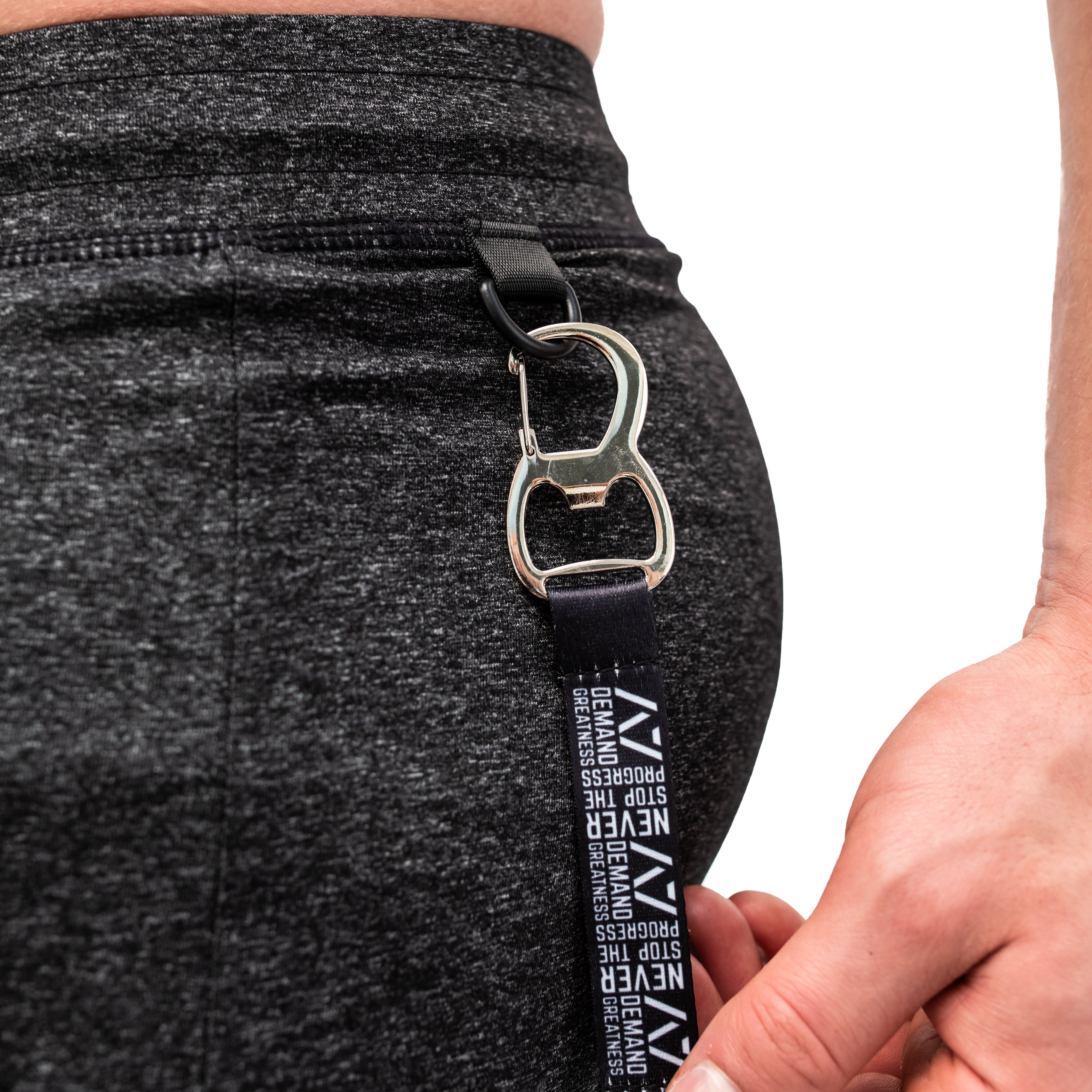 Detailed close-up of the built-in key clip on the Charcoal Defy Joggers, showing the reinforced loop attachment inside the front zip pocket for secure key storage during training.