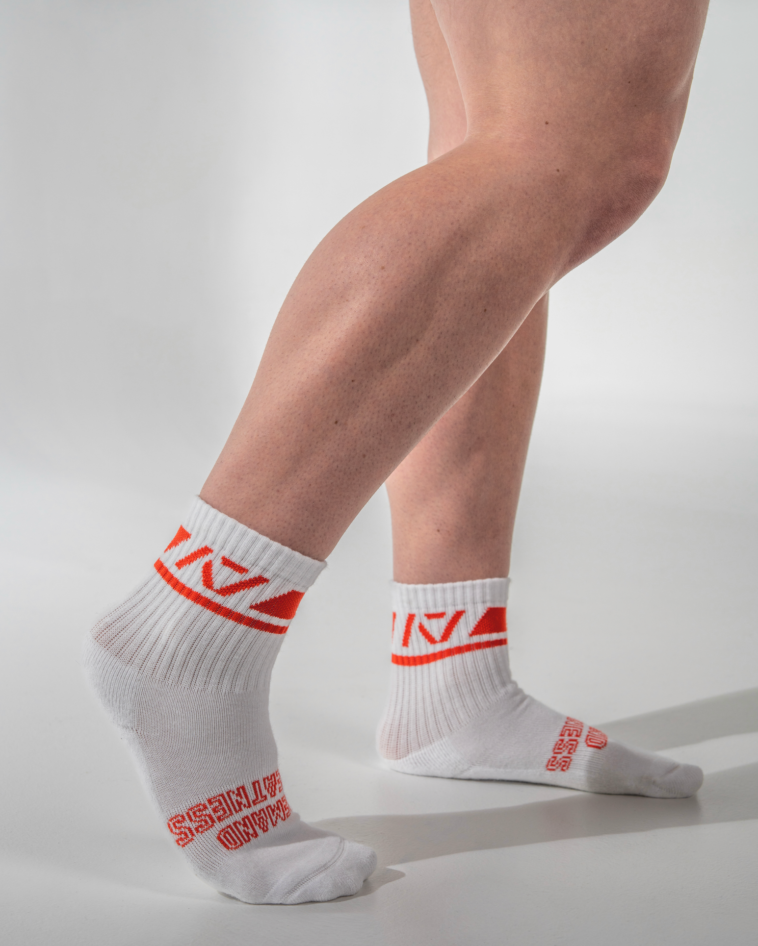 White socks with red text worn by a person on a light gray background