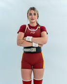 Female wearing a red and yellow rausch singlet with a white background
