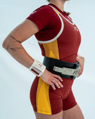 Female wearing a maroon and yellow Powerlifting Singlet showcasing the side accents on the design