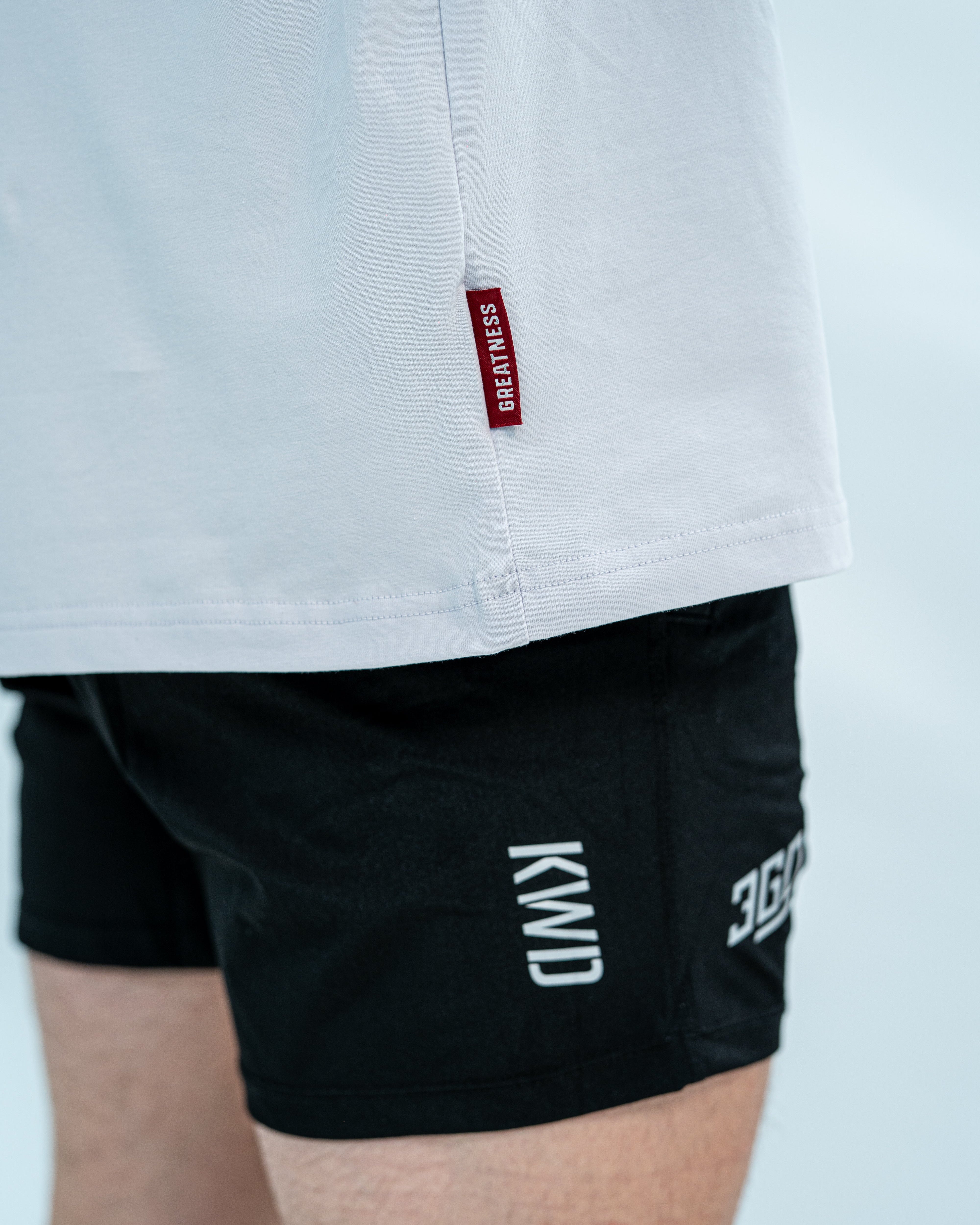 Showcasing the red hem tag of over-fit bloom shirt on male model