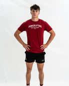 Person wearing a red 'Powerlifting' Bar Grip Shirt and black shorts on a white background