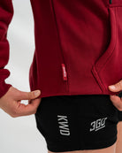 Red Bar Grip hoodie with a brand logo and black shorts with visible branding on a white background