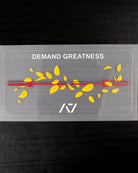 Transparent decal with 'DEMAND GREATNESS' text and yellow leaves with barbell on a black background