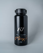 Black water bottle with decal placed on it on a gray background