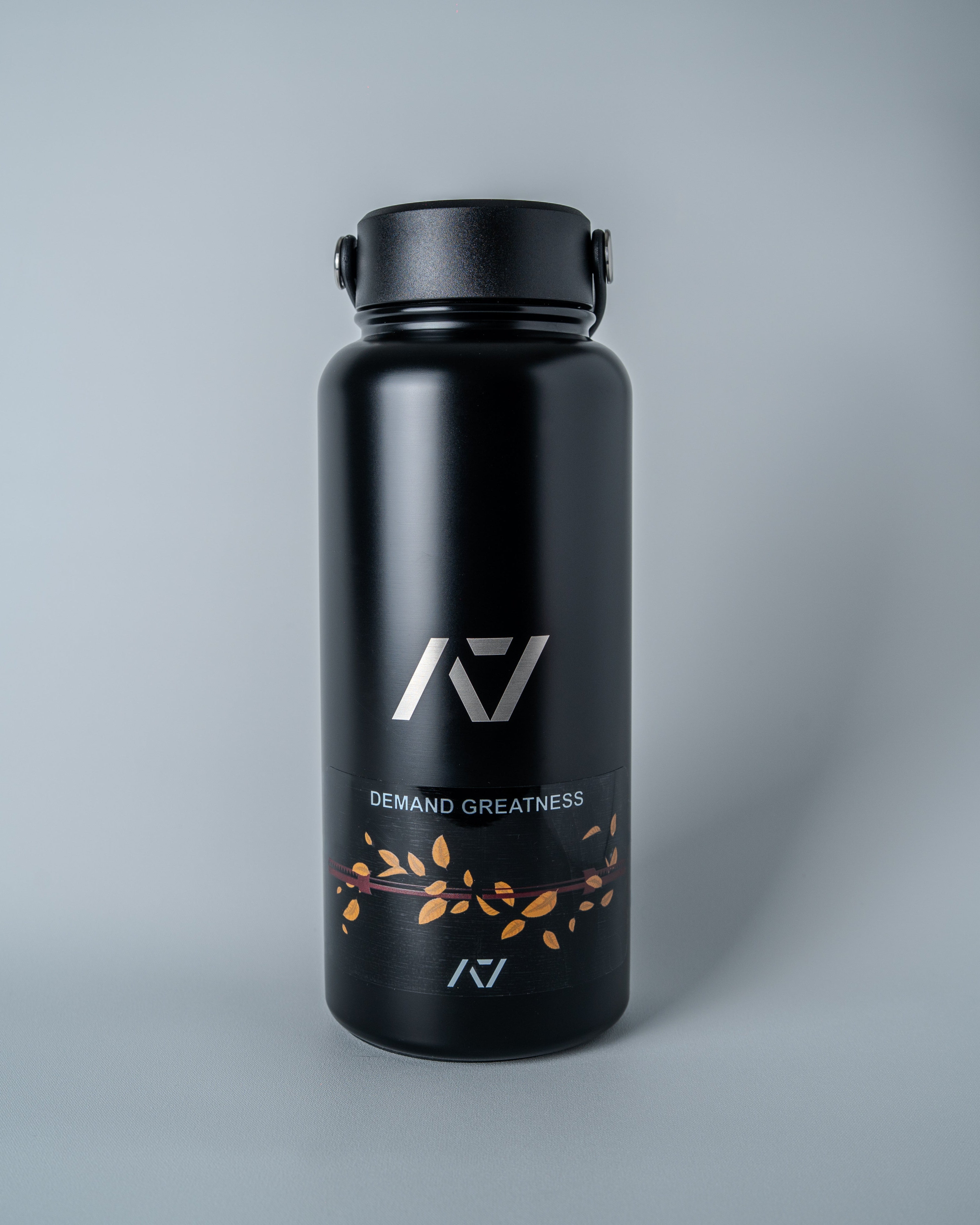 Black water bottle with decal placed on it on a gray background