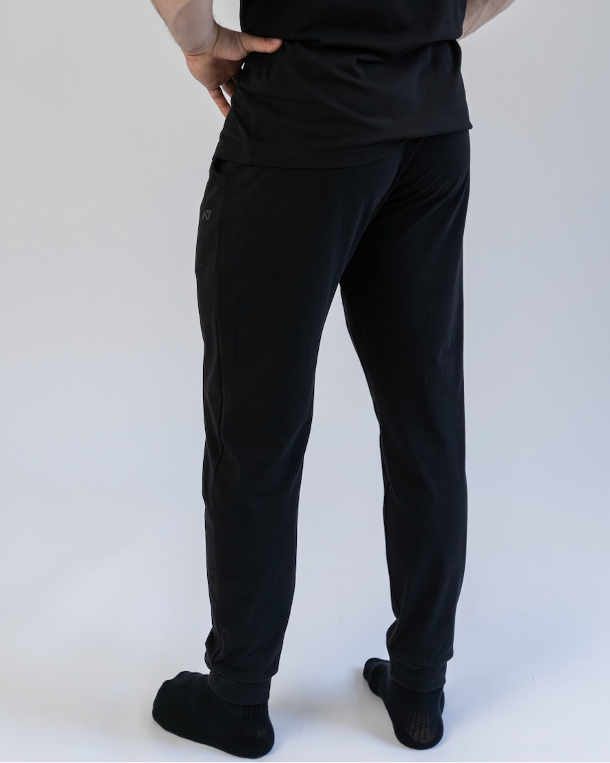 Person wearing black pants and a black shirt on a white background