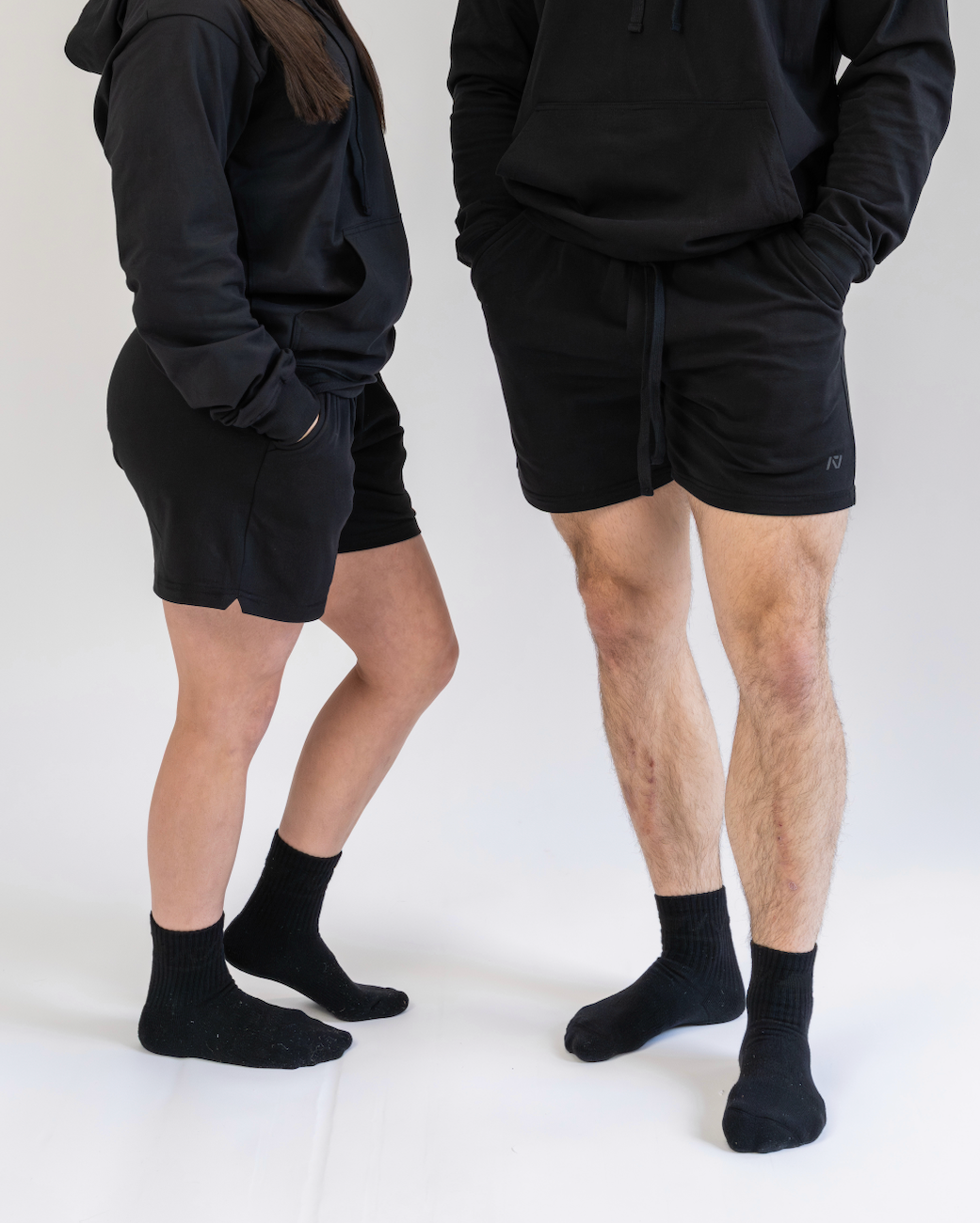 Two people wearing black athletic wear on a white background