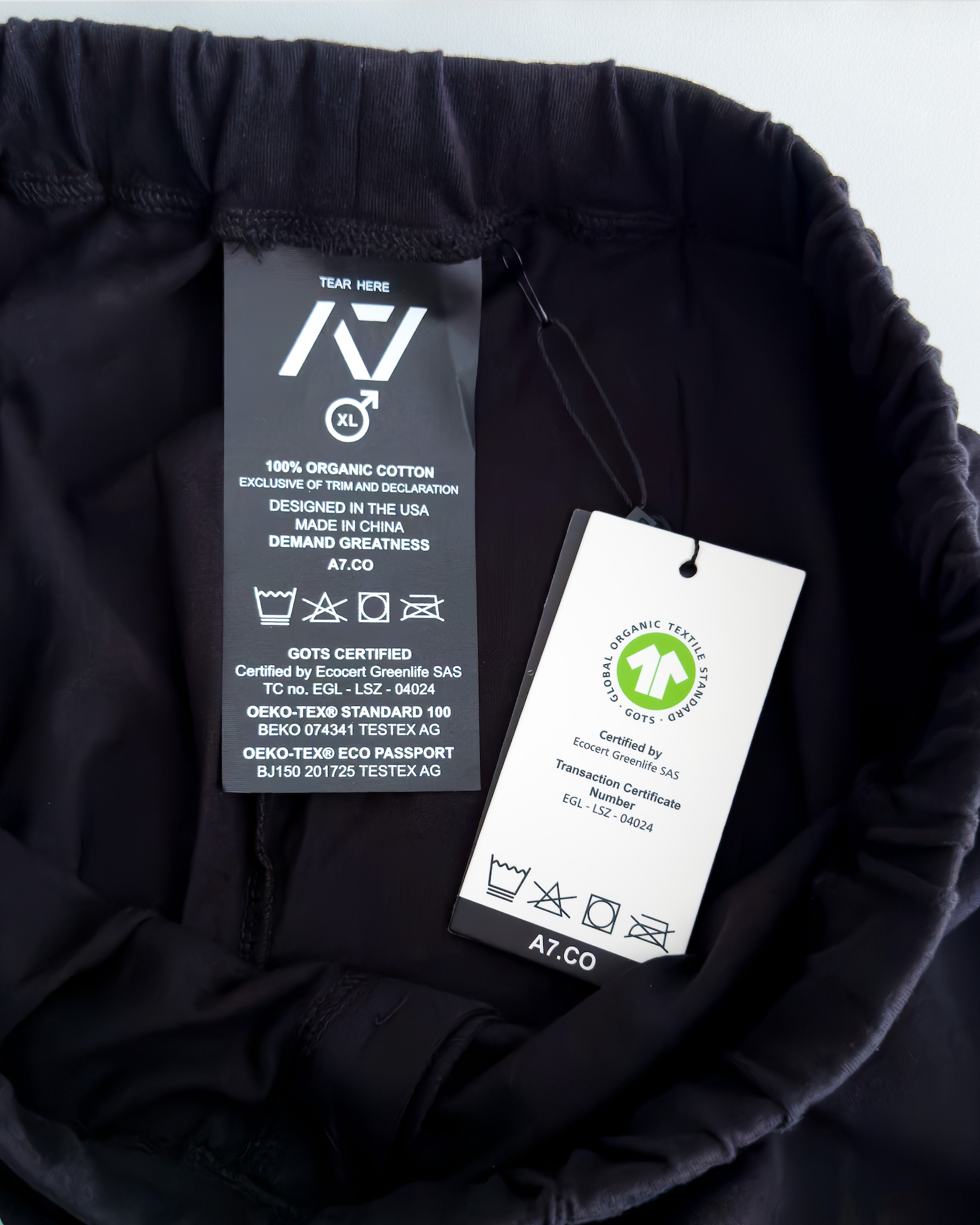 Clothing tag with certification details on a black fabric background