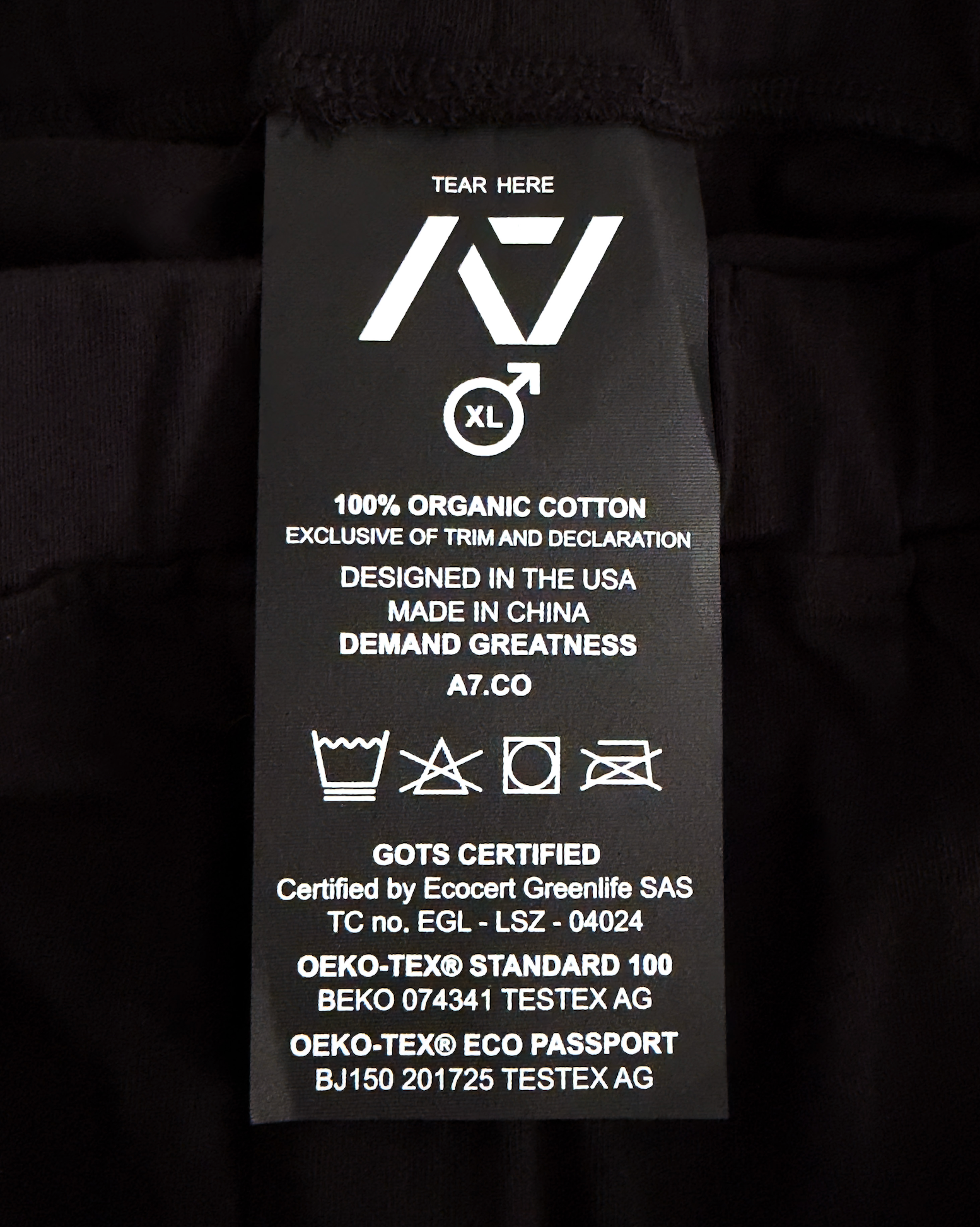 Clothing label with text and symbols on a black background