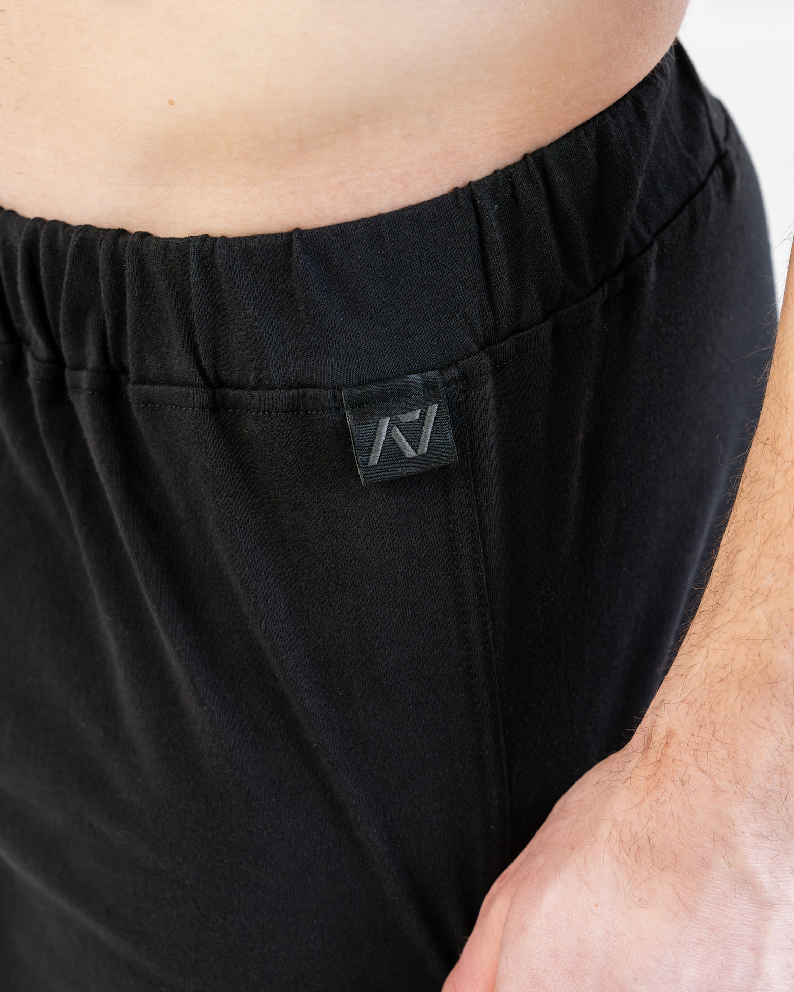 Black boxer shorts with a brand logo on the waistband against a neutral background