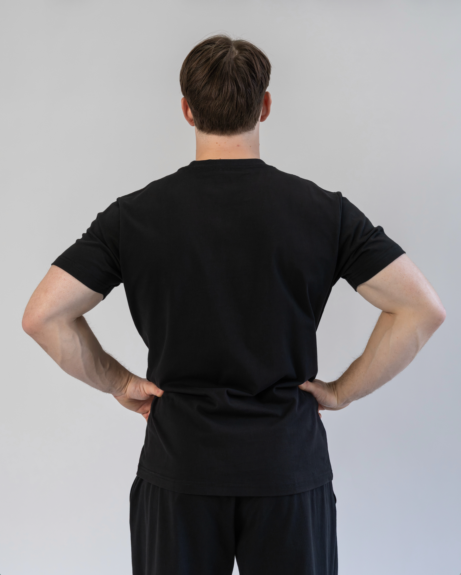 Person wearing a black outfit against a plain background