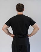 Person wearing a black outfit against a plain background