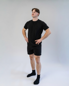 Person wearing a black t-shirt and shorts set on a white background