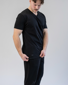 Man wearing a black t-shirt and pants on a plain background