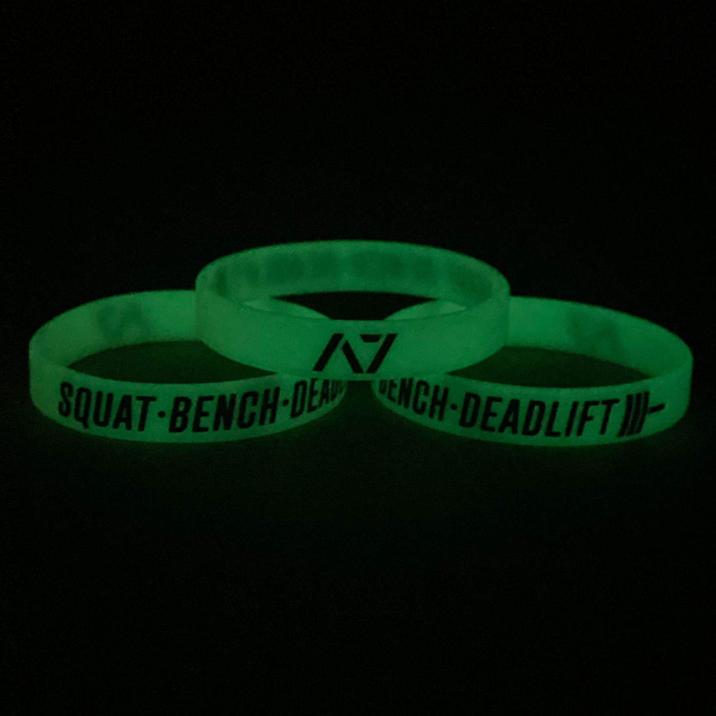 https://a7.co/cdn/shop/products/SquatbenchDeadliftWristbandGlow_1445x.png?v=1626989907